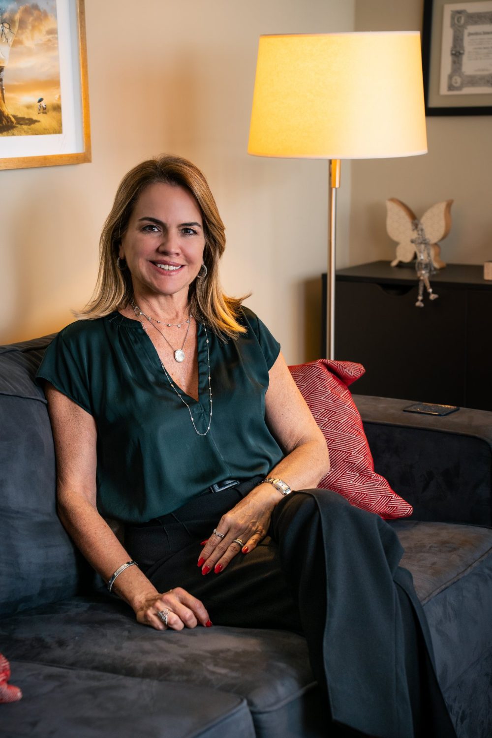 Lecticia Raposo sentada de forma tranquila no sofá do consultório